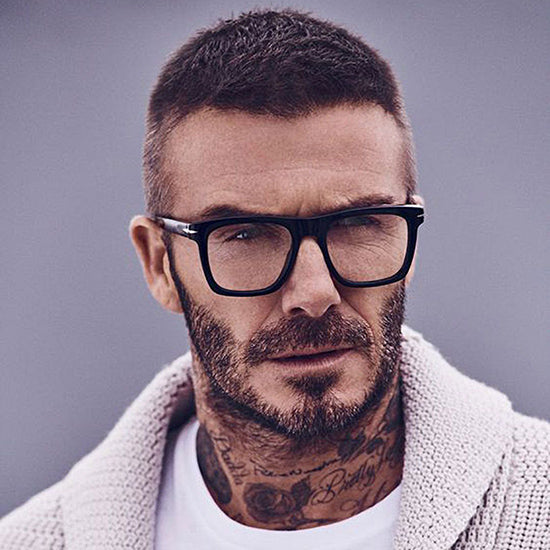 Close-up portrait of a man wearing black square-frame eyeglasses. The modern and minimalist design conveys sophistication and comfort, making the frame ideal for those seeking stylish and contemporary prescription eyewear.