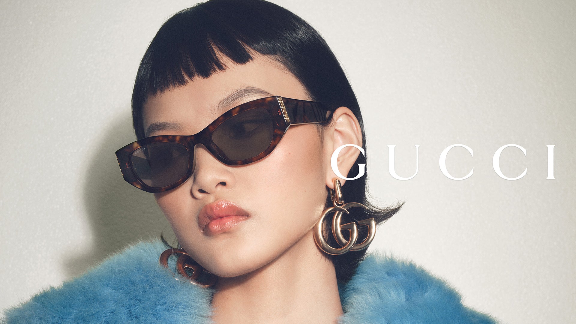 Person wearing Gucci sunglasses with the brand name displayed