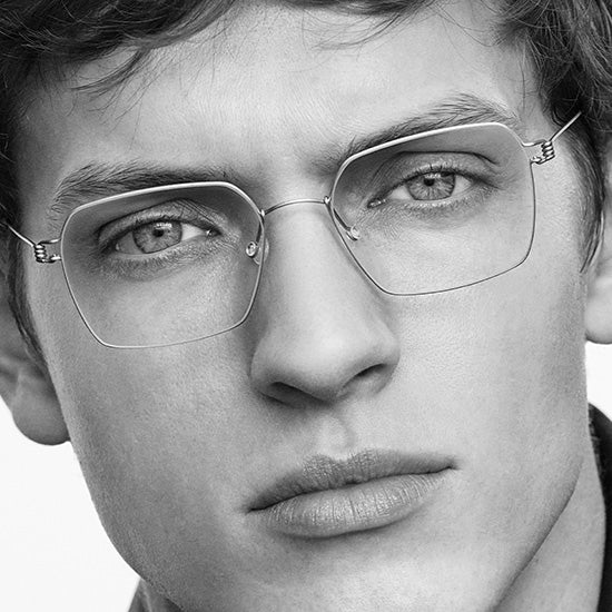 Young man wearing Lindberg Air Titanium Rim glasses, lightweight titanium frame with minimalist design.