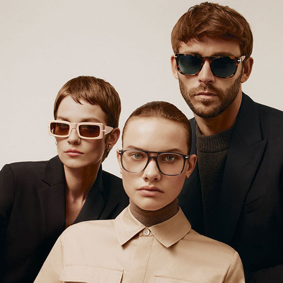 Three models wearing Persol sunglasses and eyeglasses with modern, minimalist designs; square and round acetate frames in neutral tones.